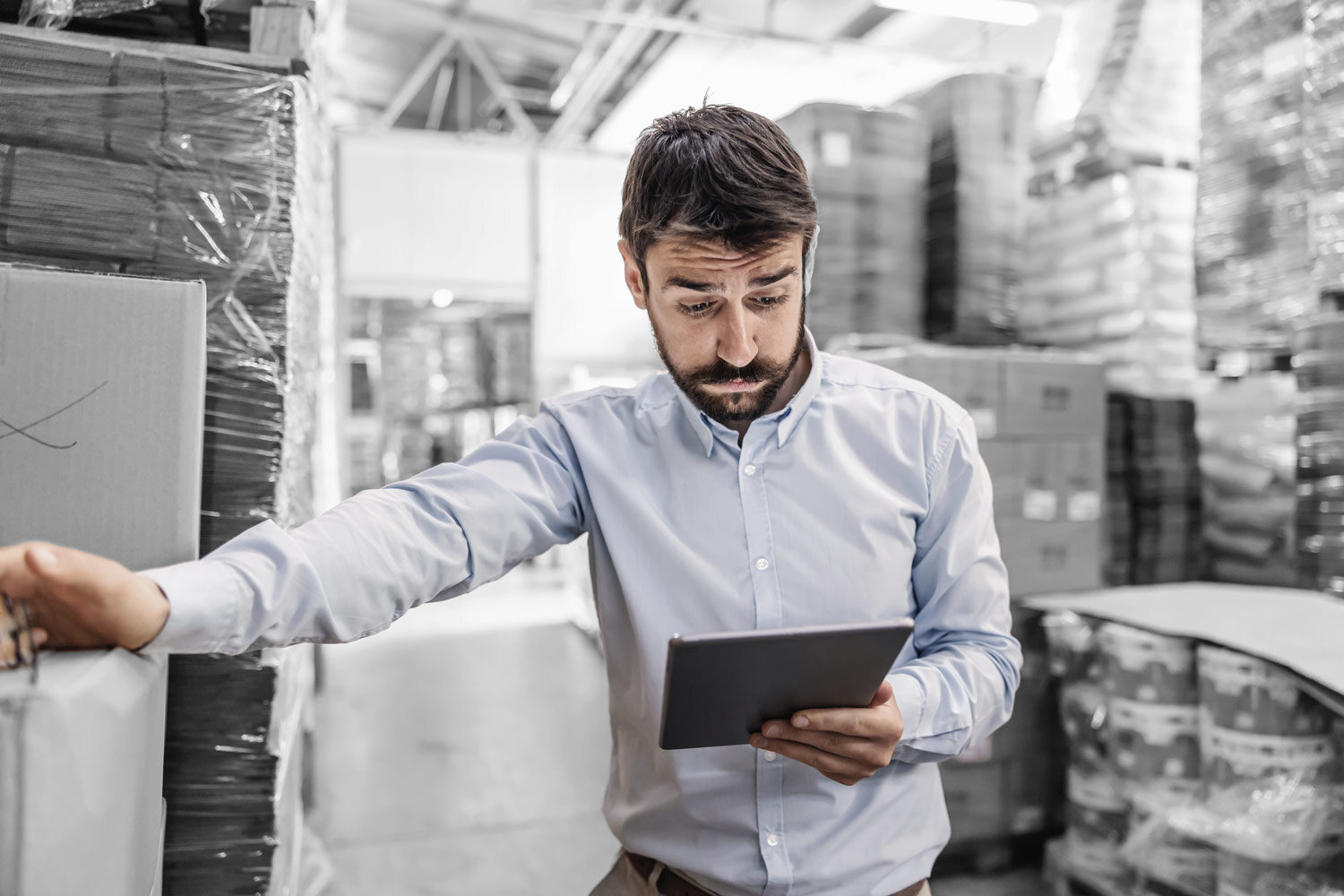 An overwhelmed warehouse manager in a messy warehouse.
